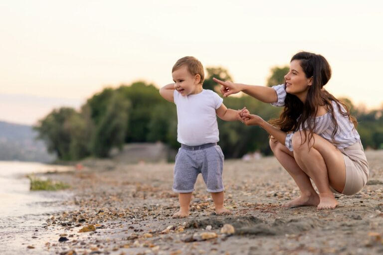 Mother and toddler son throwing pebbles into river